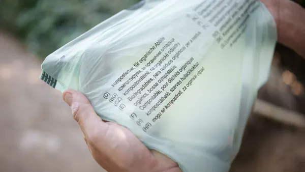 hands hold compostable bag