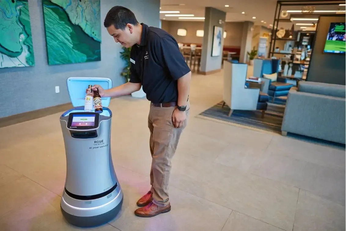 A staffer at the Hotel Trio Healdsburg places drinks within a Relay robot.