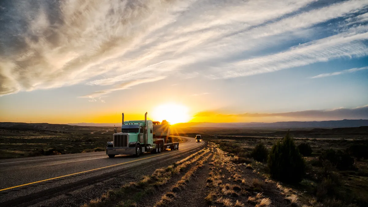 Lone truck with semi-trailer at sunset on a desert highway