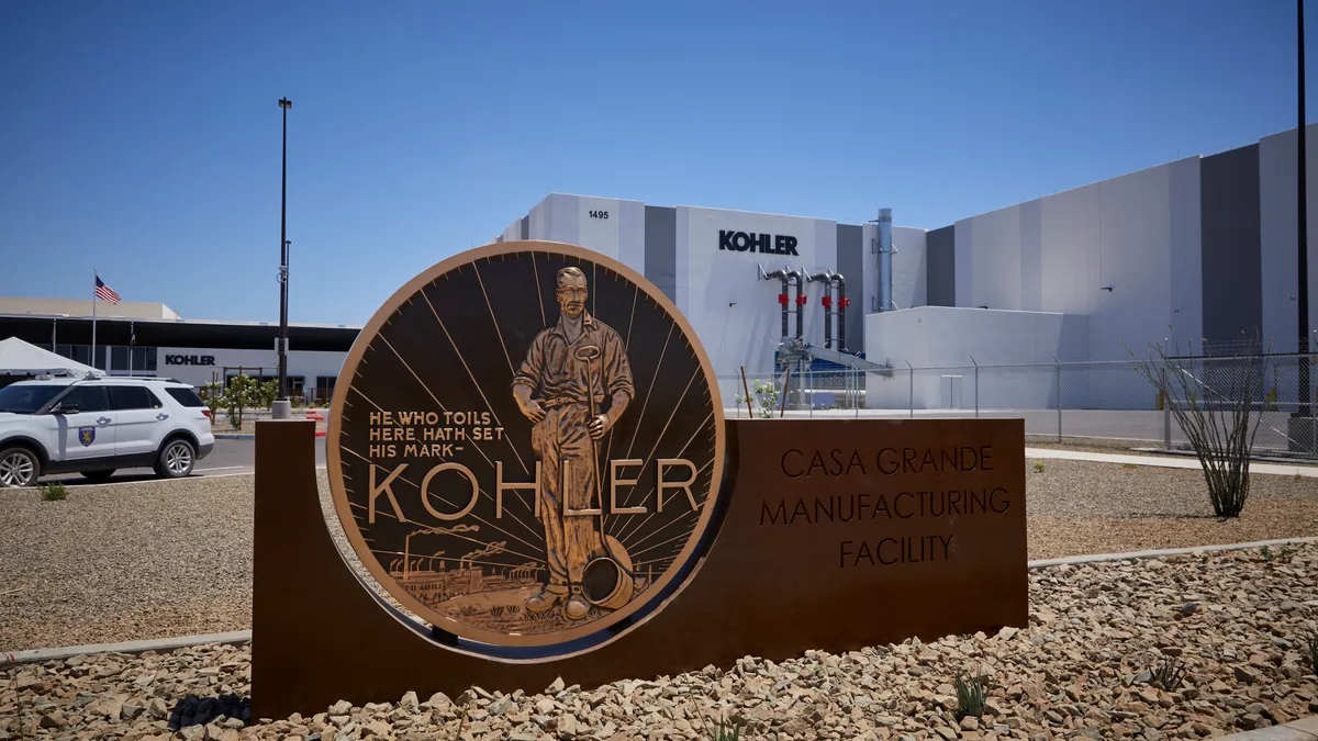 A Kohler Casa Grande facility sign with a quote, "He who tils here hath set his mark" in bronze.