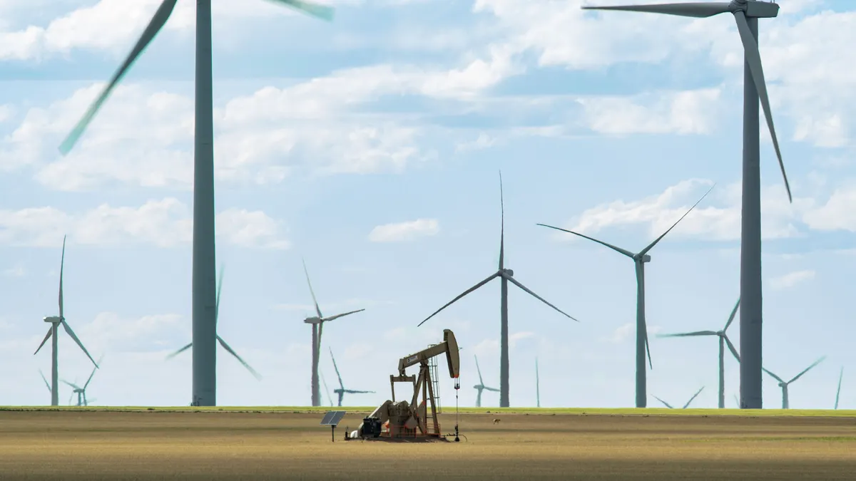 Wind turbines stand in a field.