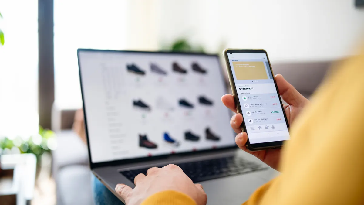 A person shops online on a laptop and phone.