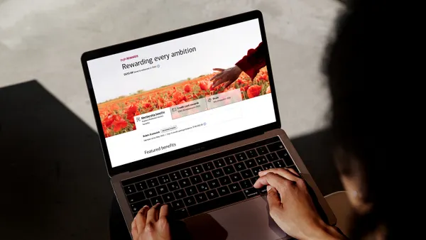 A person uses a laptop computer showing a bank rewards screen