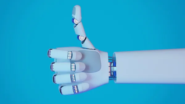 A robot hand gives a thumbs up of approval in front of a solid blue background