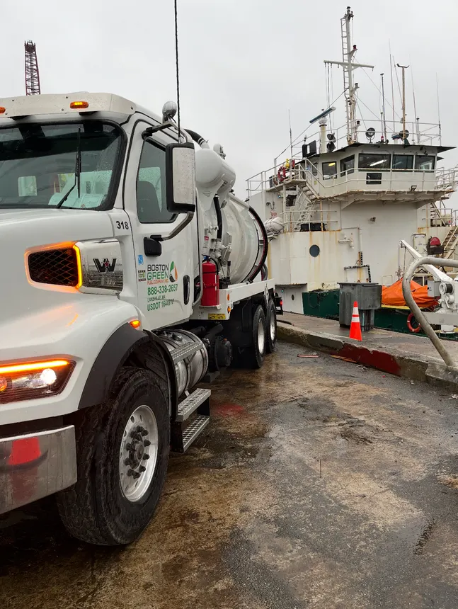 A Boston Green truck pulled up next to a ship