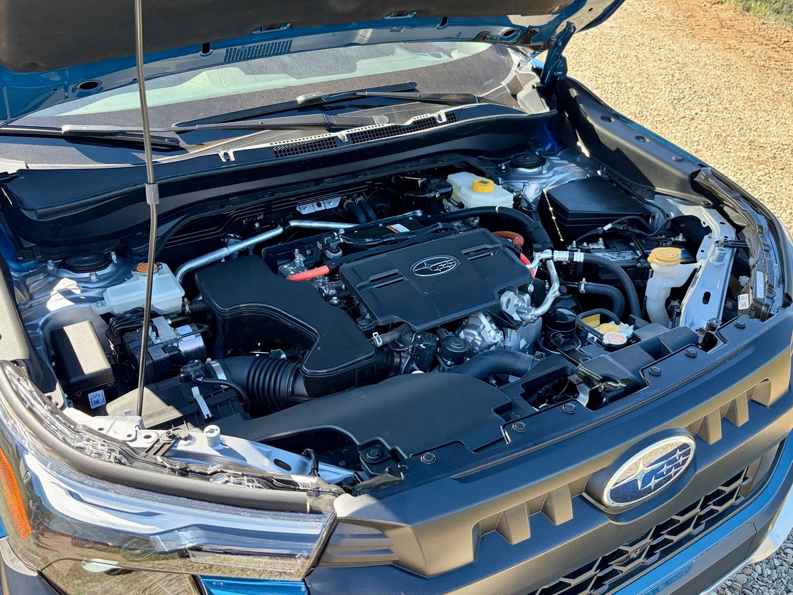 Under the hood of the 2027 Subaru Forester Wilderness, in the bright sun.