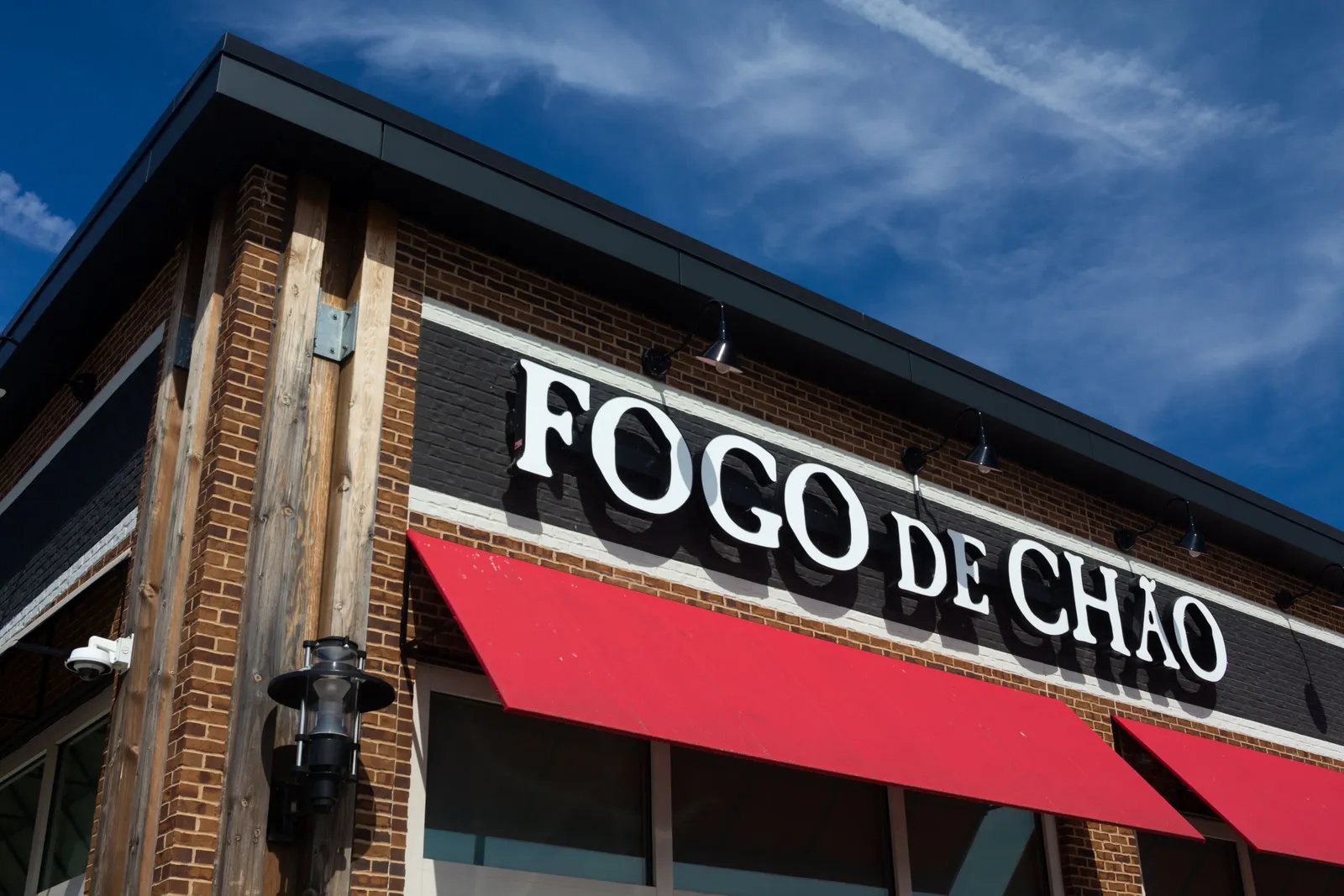 A imae of a corner of a brick building with Fogo De Chao in white letters on the side.