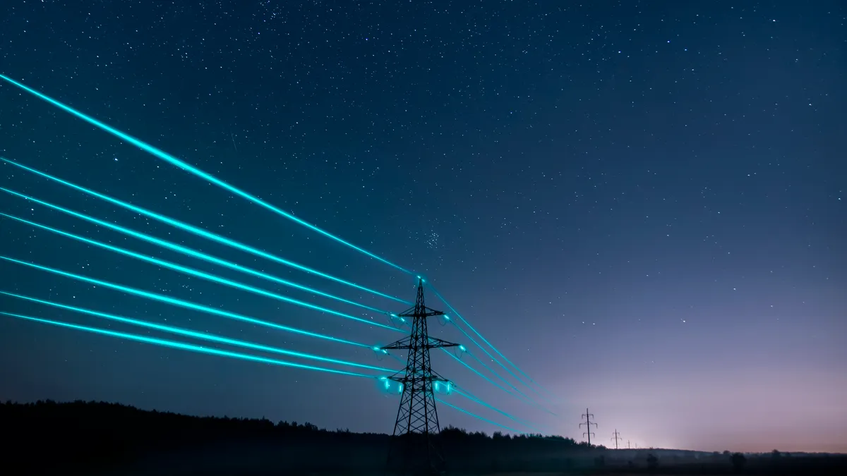 Electricity transmission towers with glowing wires against the starry sky.