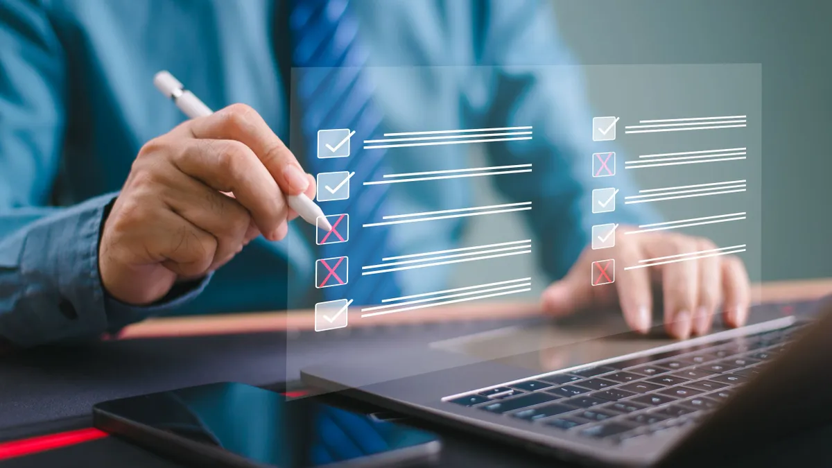 A person checks off a list on a projected screen from their laptop.