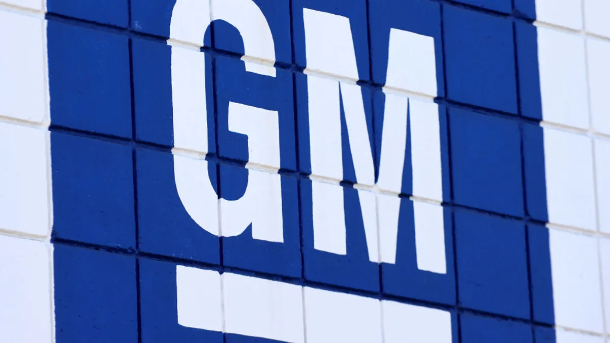 A blue sign with white lettering reads "GM."