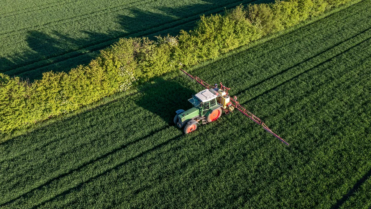 an aerial view of a tractor on a farm