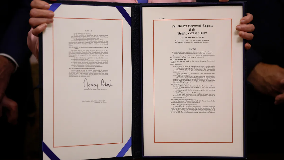 Speaker of the House Nancy Pelosi (D-CA) holds the Ocean Shipping Reform Act while posing for photographs during the enrollment ceremony in her ceremonial office at the U.S. Capitol on June 14, 2022.