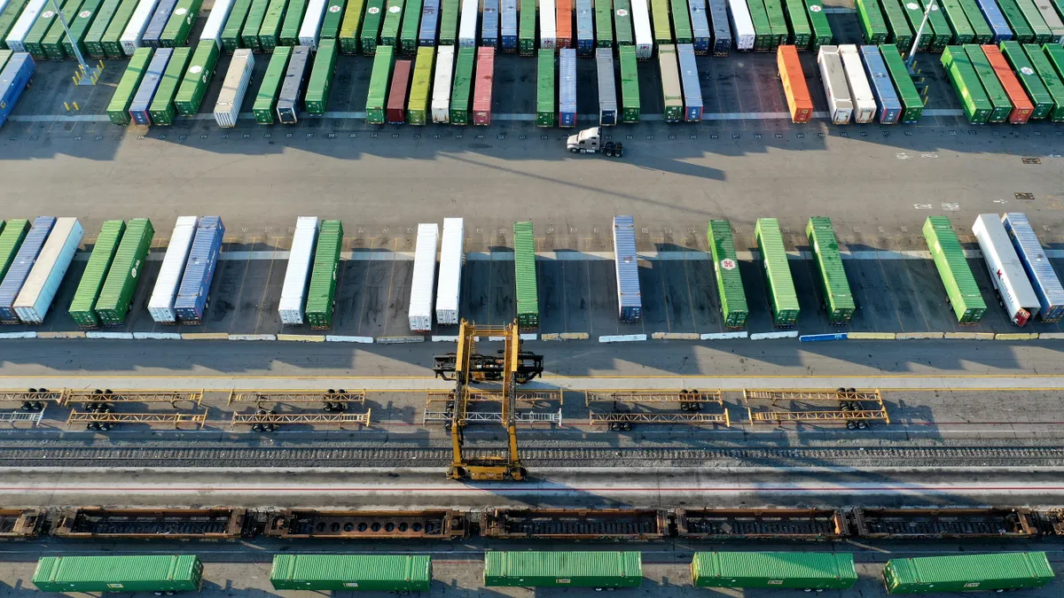 In an aerial view, shipping containers sit on truck transport chassis in a rail yard on October 22, 2021 in Los Angeles, California.