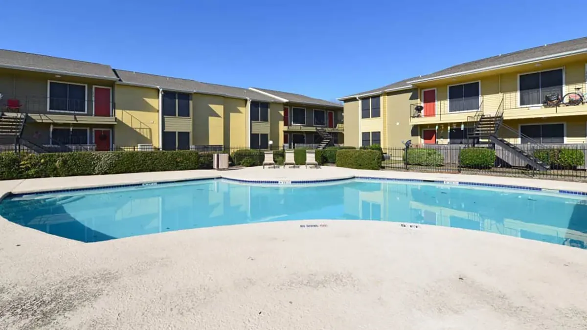 Two-story apartments with a pool in the foreground.