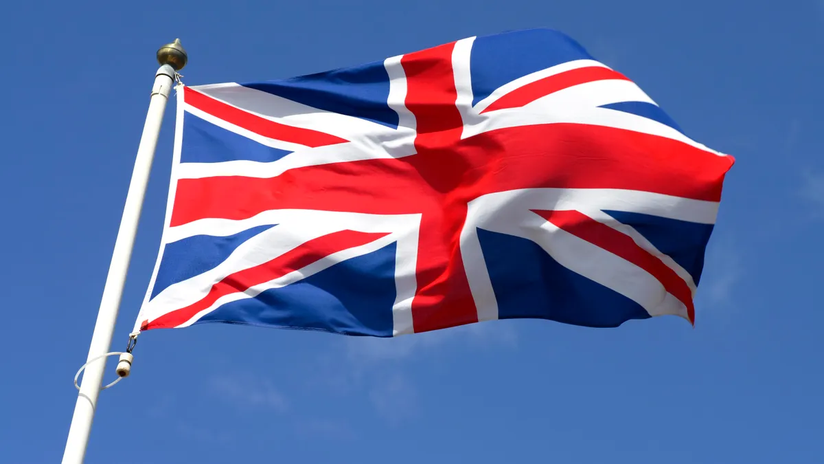 A union jack flag waves in the wind