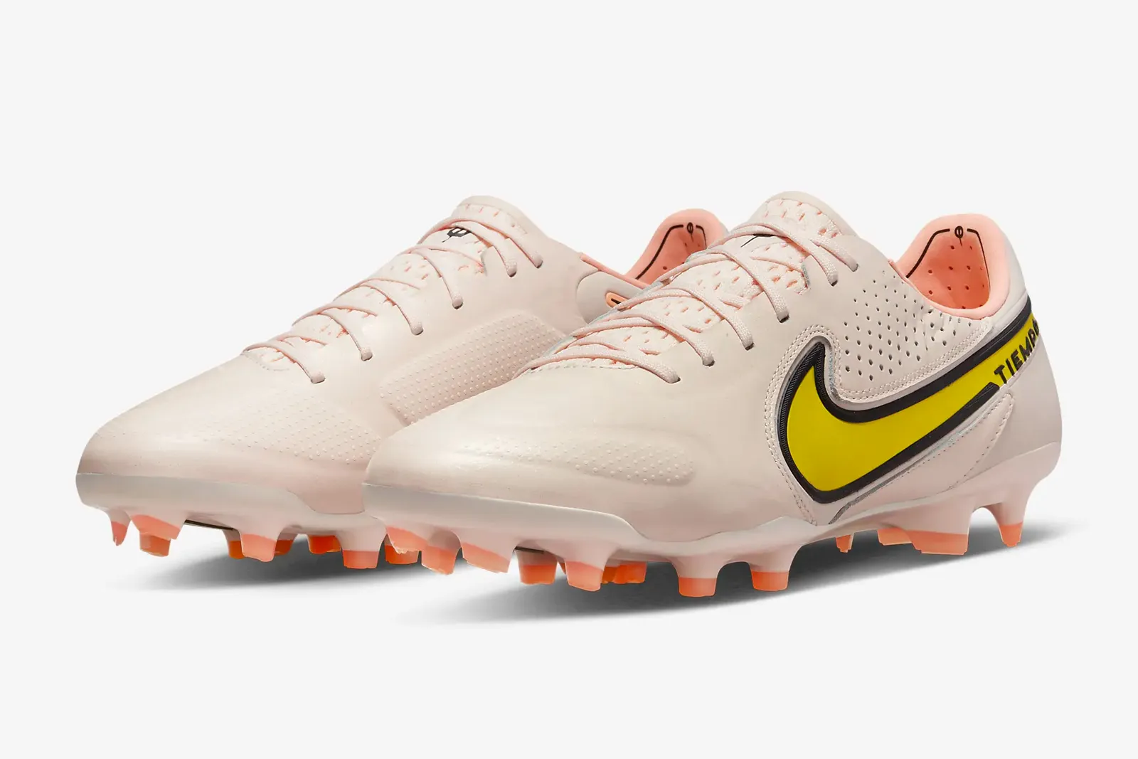 a pair of pink soccer cleats sits on a white background