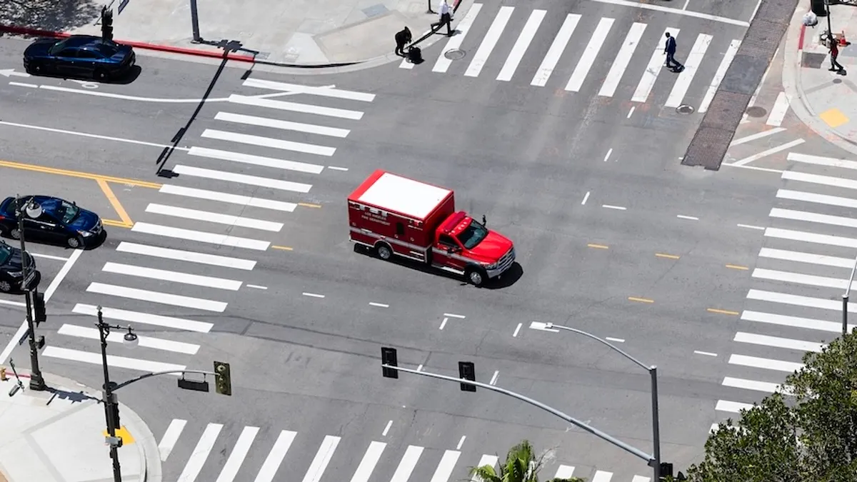 Bird's-eye view of a crowded intersection featuring a mix of cars and trucks on the road.