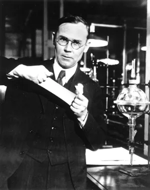 A person in glasses, jacket and tie works in a laboratory