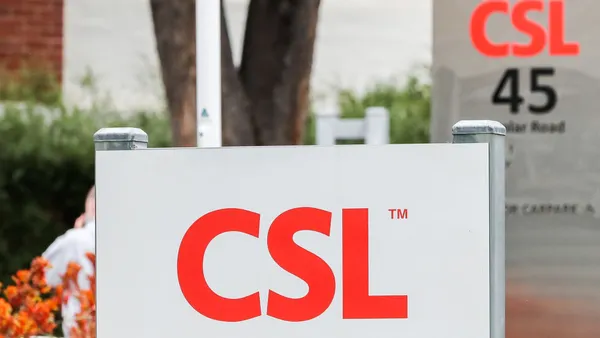 Two signs bearing the logo for CSL are seen outside of a corporate office