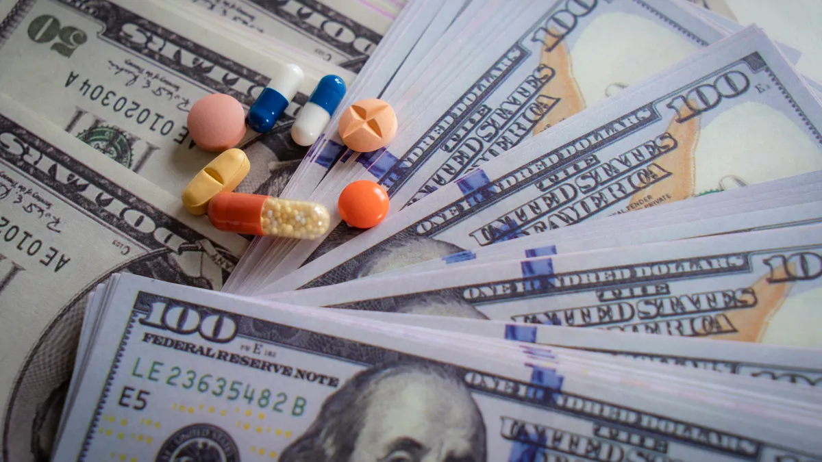 Pills lie on top of hundred dollar bills.