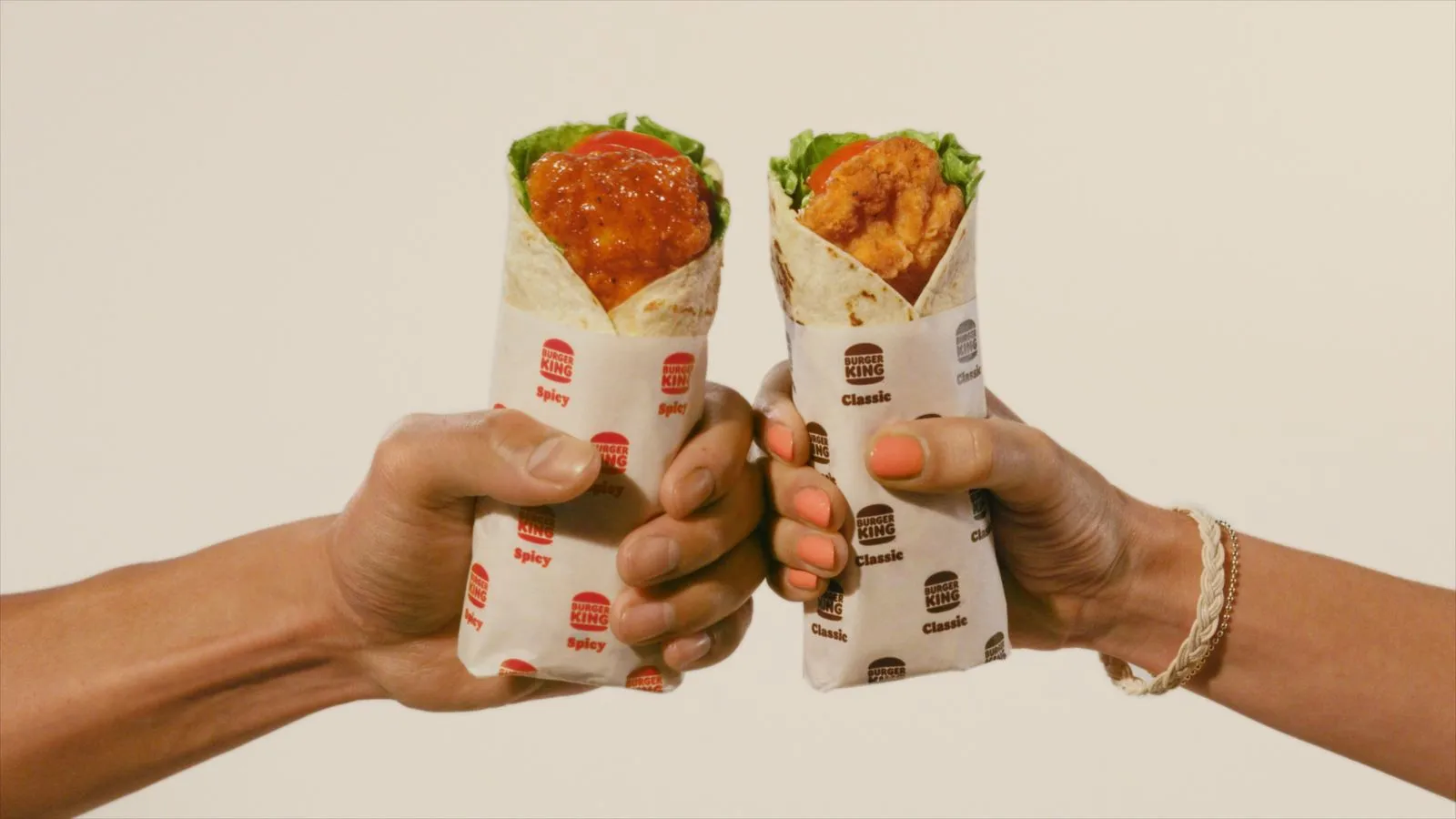 Two hands holding Burger King wraps