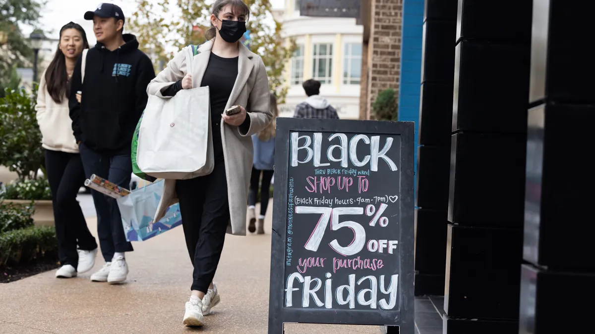 Shoppers pass stores on Black Friday.