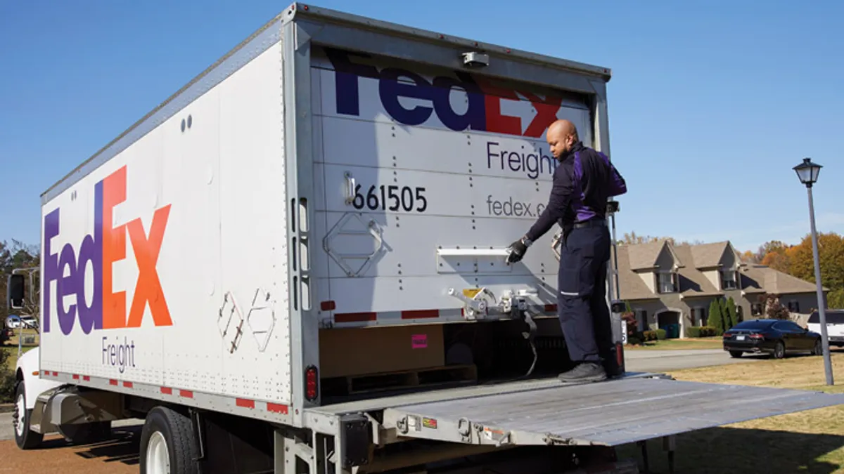 A parcel carrier worker opening a freight truck.