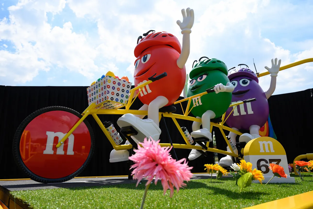A statue of three M&amp;M's riding a bike in partnership with the Tour de France