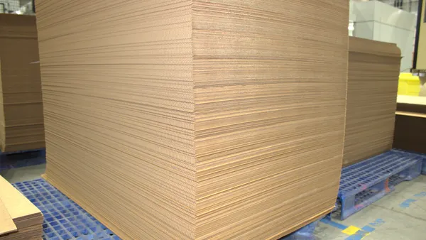 Stacks of flattened corrugated boxes at an industrial facility.