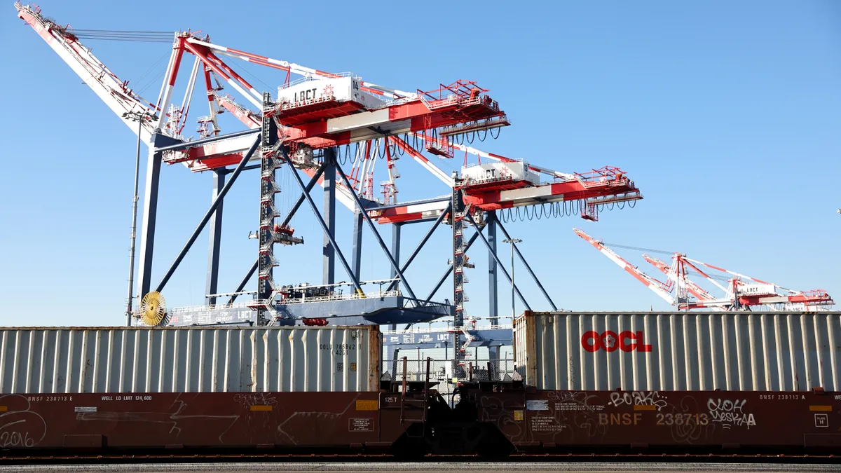 Freight rail cars sit in front of cranes at the Port of Long Beach on November 22, 2022 in Long Beach, California.