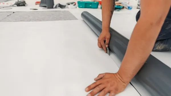 A worker installing water-resistant membranes on a commercial roof.
