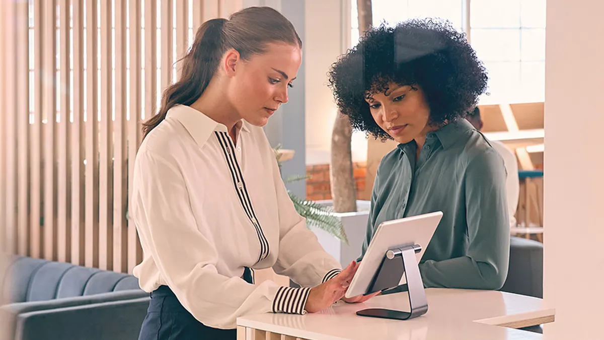 Person with suitcase checking into hotel.