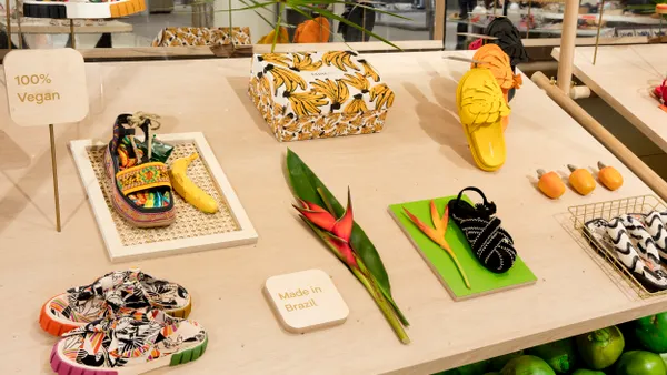 Colorful shoes sit on a display surrounded by different types of heliconia flowers.