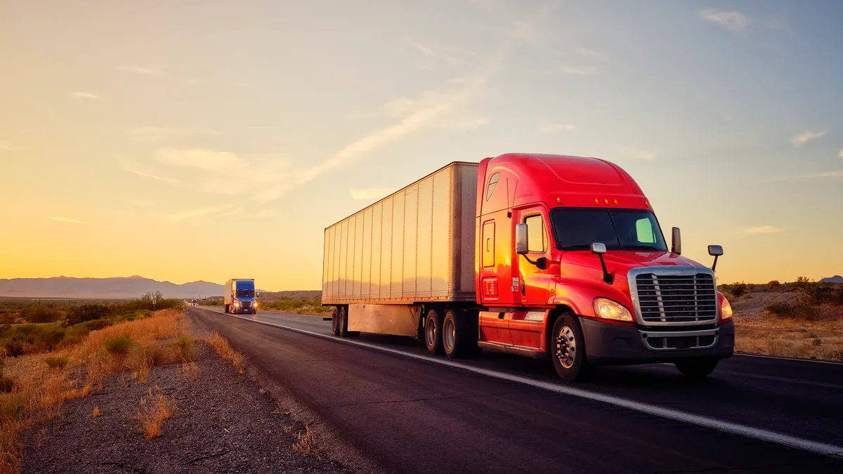 Truck hauling freight on the open highway in the western U.S. under an evening sky.