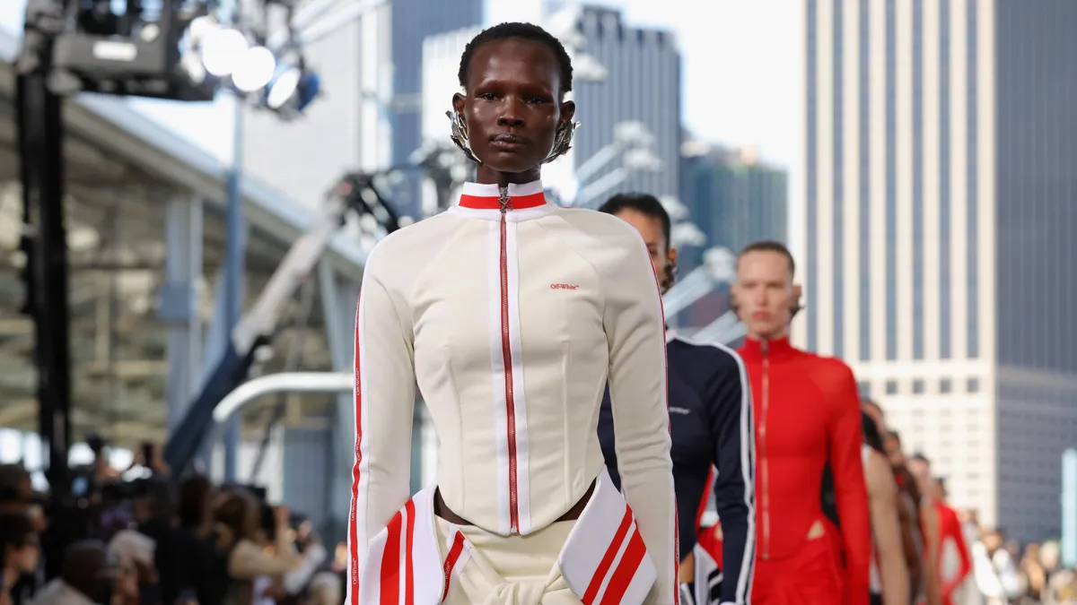 Models in sporty attire walk down a runway.