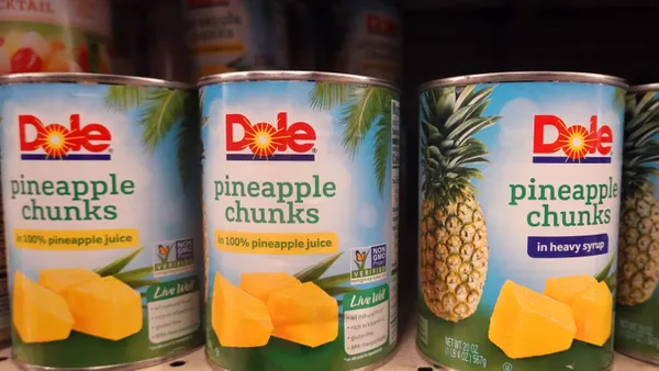 Cans of pineapple chunks sit on a shelf at a grocery store on July 26, 2021, in Chicago. The cans read "Dole pineapple chunks in 100% pineapple juice."