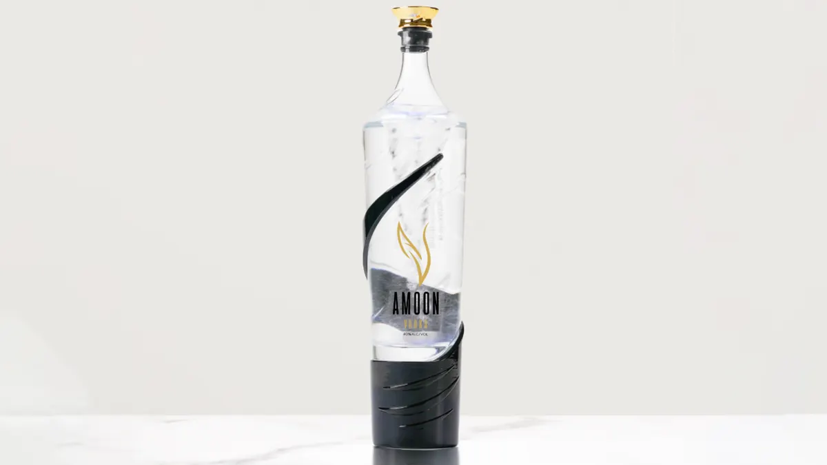 A bottle containing clear liquid with a device at the bottom that creates a vortex inside the bottle.