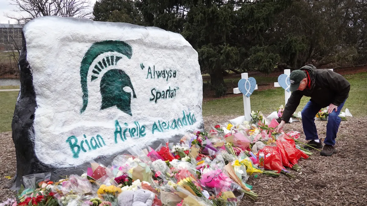 Michigan State University campus lawn with rock painted with Spartan logo and the names of students who were killed.