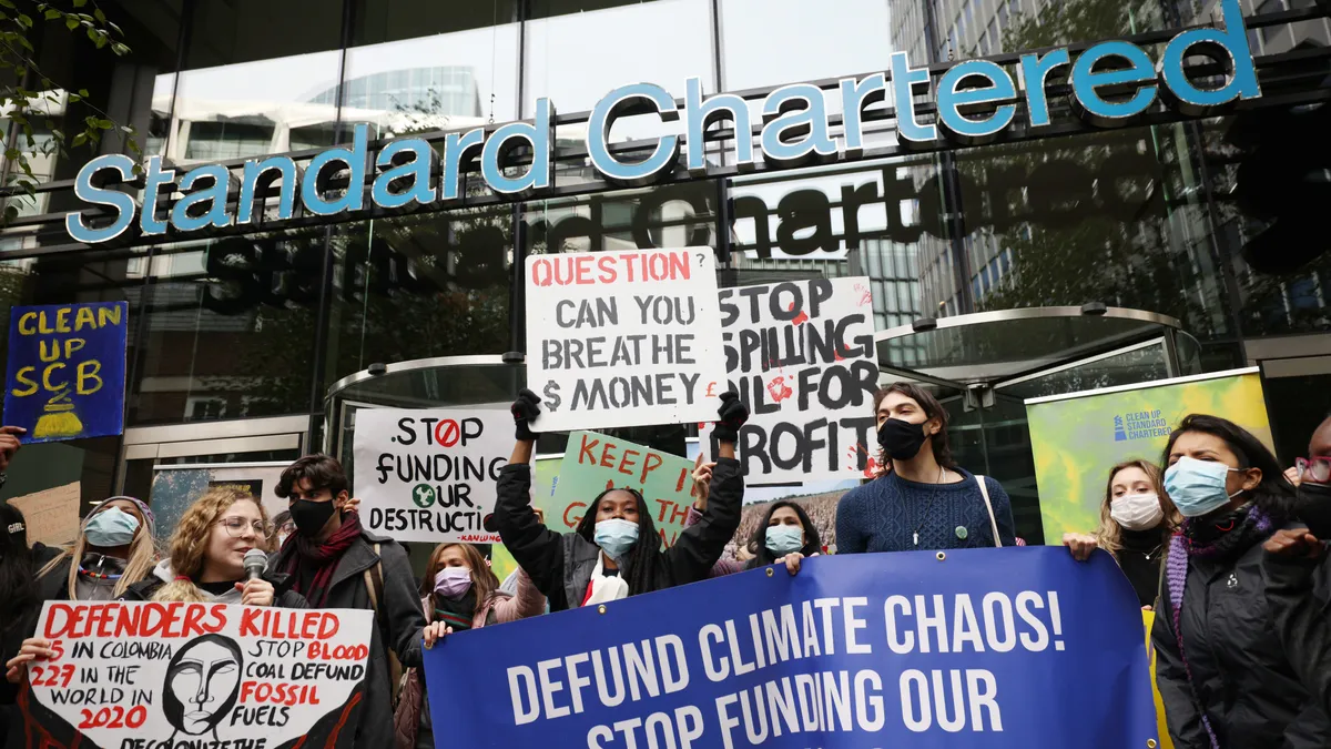 Climate activists protest outside the headquarters of Standard Chartered.