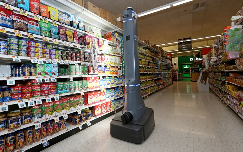 A tall, gray robot in a grocery aisle.