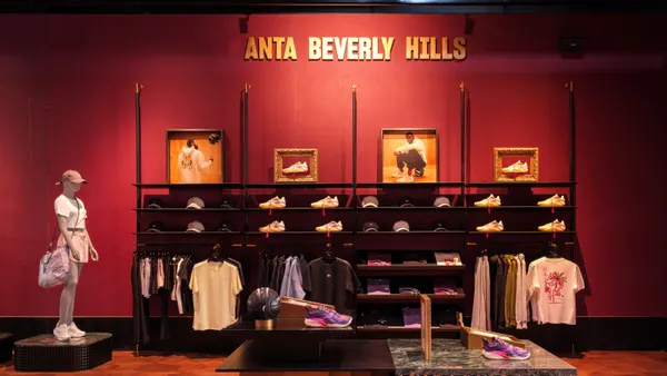 A red wall featuring a display of shoes and apparel with the words "Anta Beverly Hills" above in yellow.