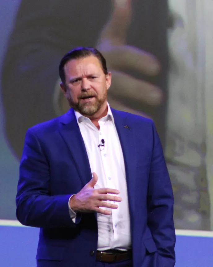 A person wearing a blue suit speaks.
