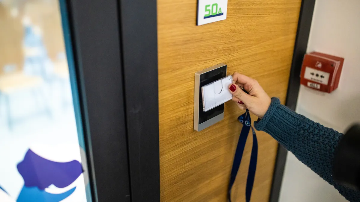 A person uses an ID card to gain access to a building.