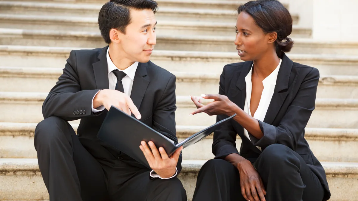 Two ethnically diverse attorneys speaking on the courthouse steps