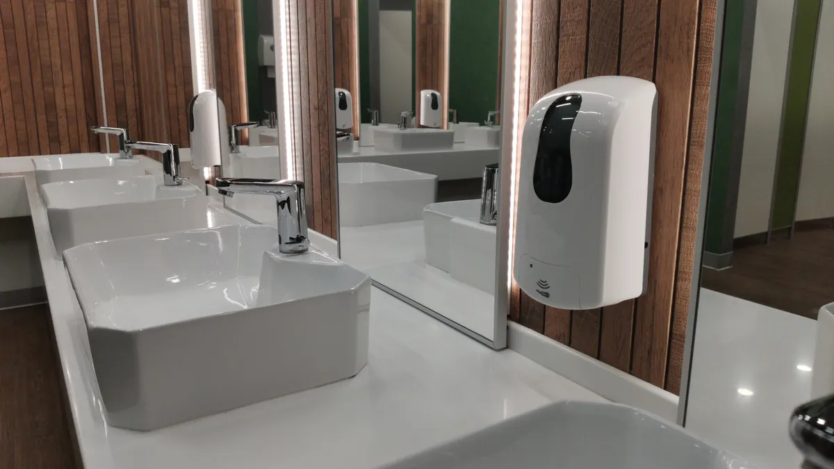 An automatic liquid soap dispenser in a public toilet.
