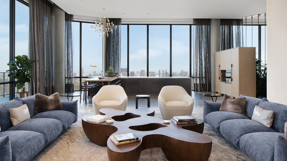 A lounge space in an apartment building with a skyline view outside the window.