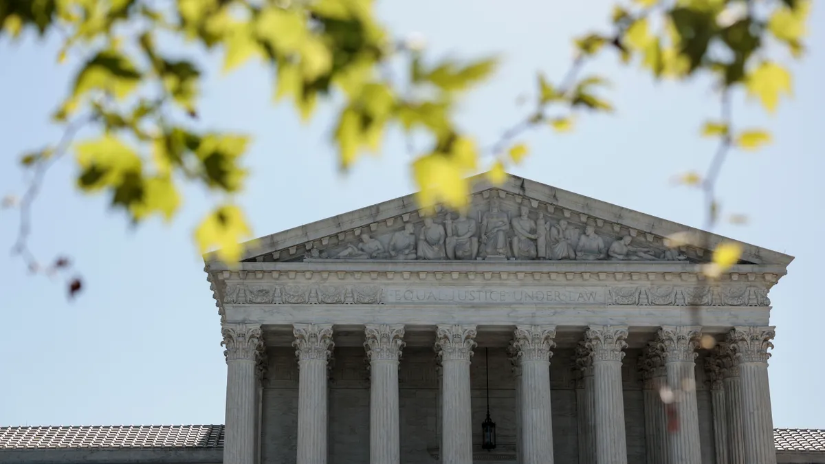 The U.S. Supreme Court is seen in spring through the branches of a tree.