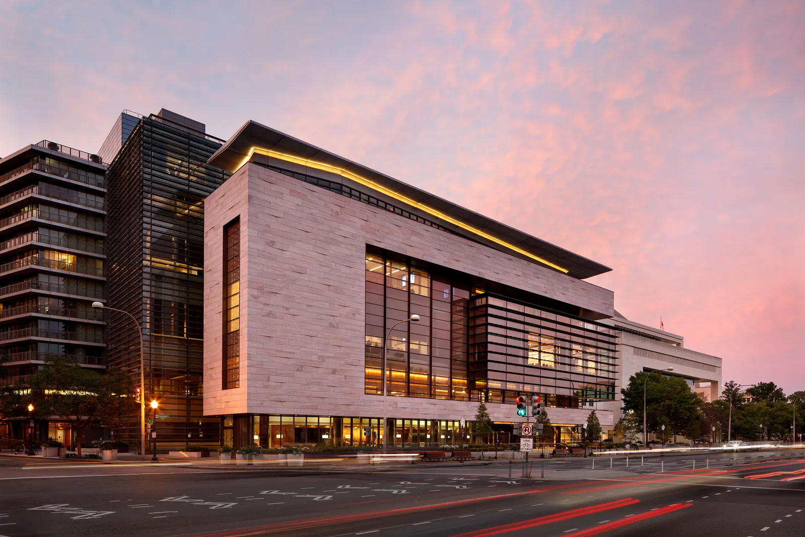 A rendering of the exterior of a modern building at sunset.