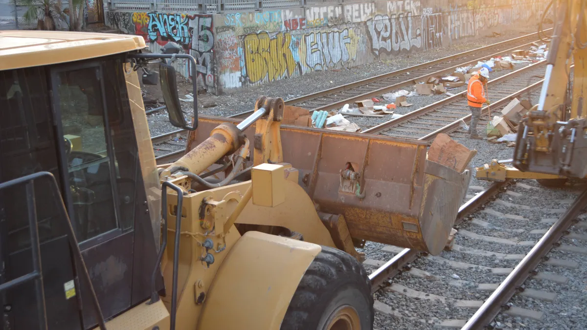 A clean up crew picking up debris from the tracks outside Union Pacific's rail yard in Los Angeles, on Jan. 21, 2022.