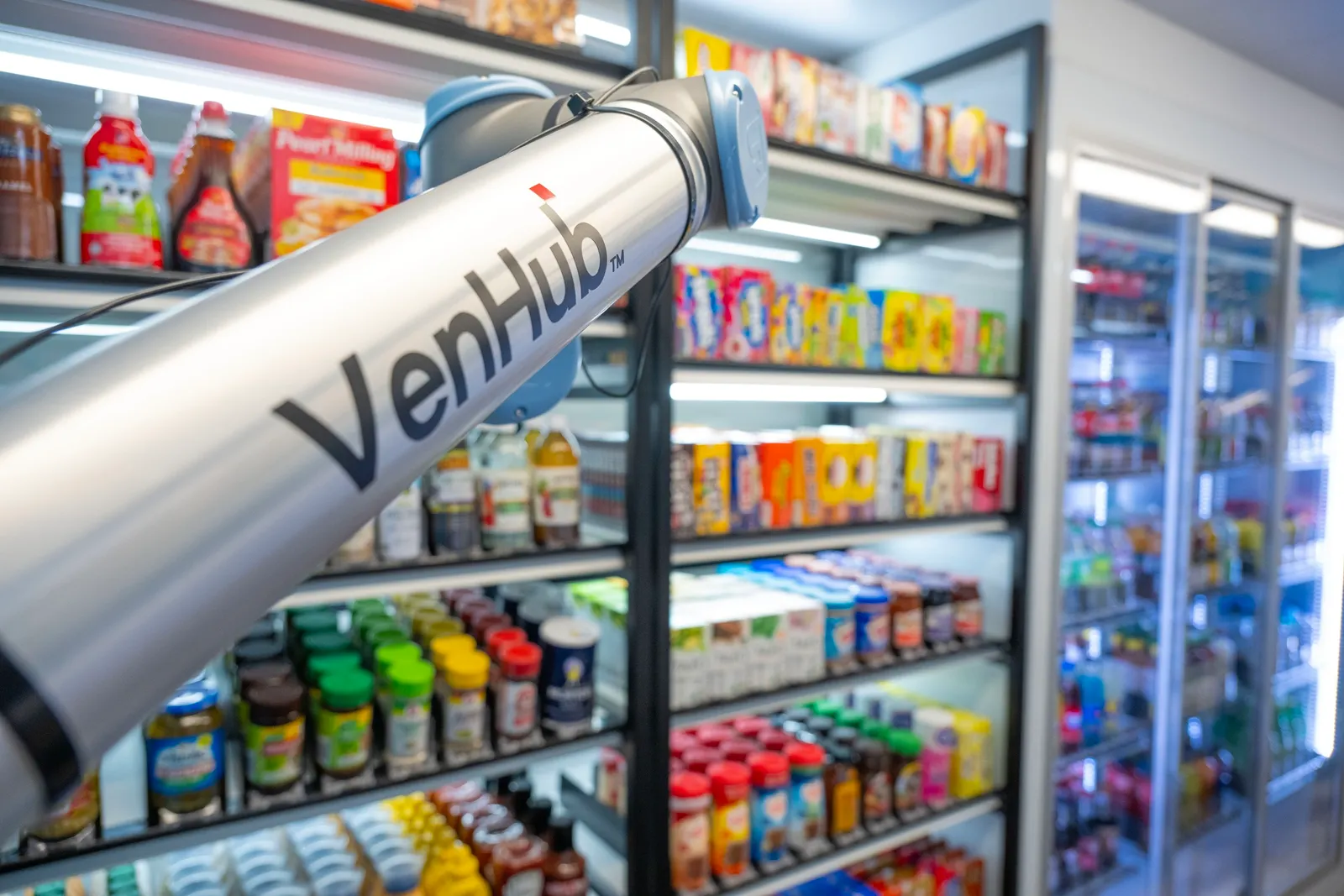 A photo of a robotic arm inside a store. Text on the arm says Venhub.